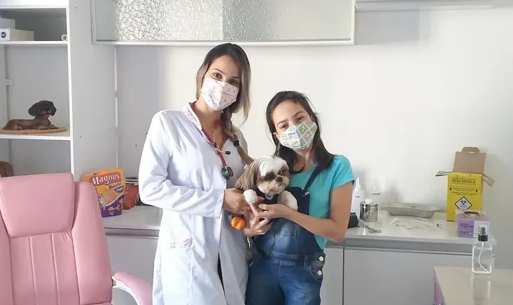 Veterinária e tutora com um shih-tzu no consultório da Bemficavet
