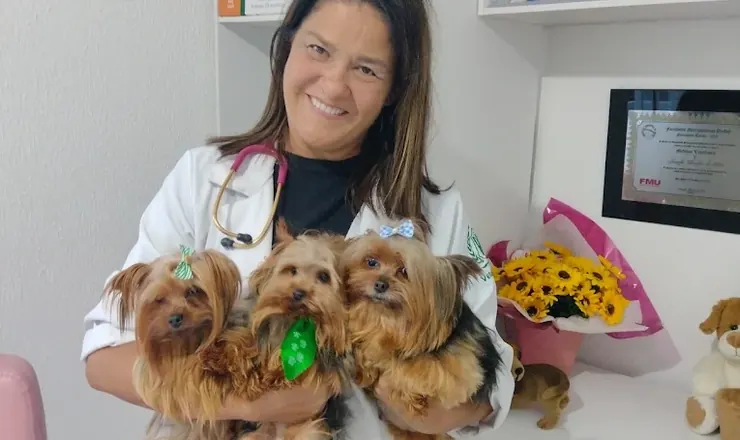 Veterinária da Bemficavet com três yorkshires no colo